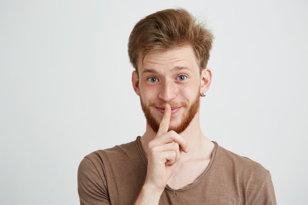 portrait young handsome man with beard smiling showing keep silence Servicios de limpieza